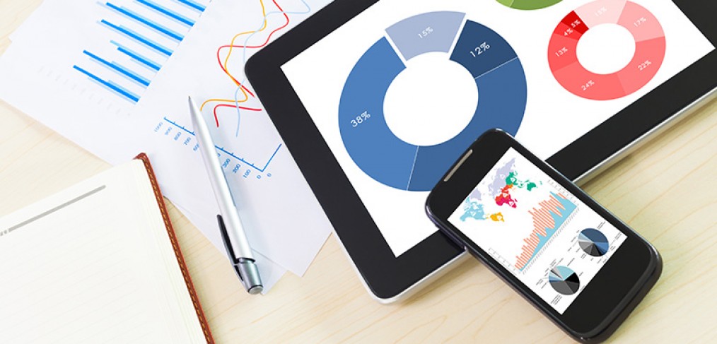 Stock image of paper, iPone, and tablet with graphs and charts on them